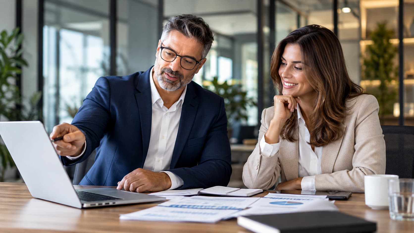 A GCMS specialist walking a business owner through pricing figures on a laptop